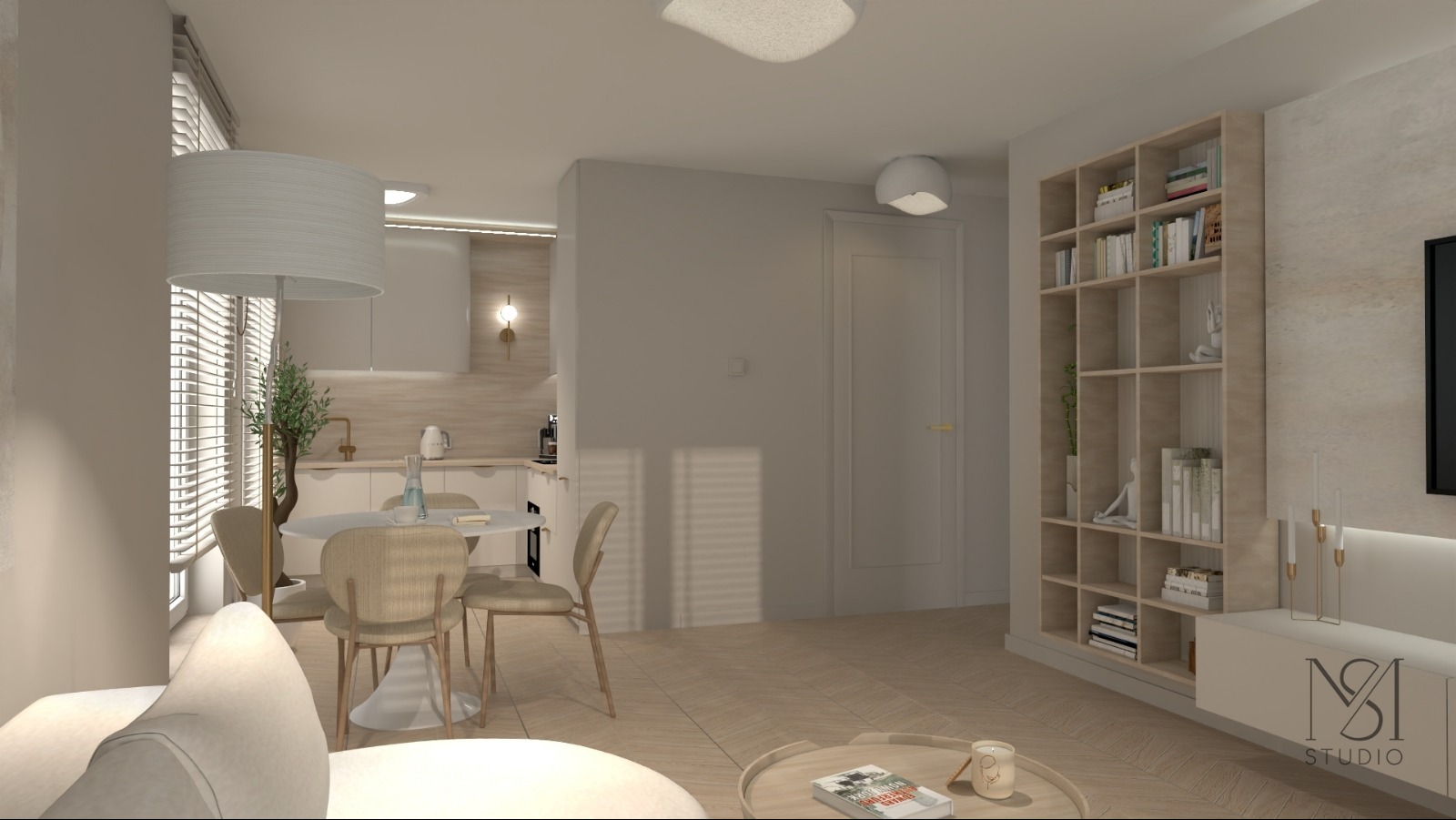 Jasne wnętrze mieszkania z otwartą kuchnią, okrągłym stołem i krzesłami. Na pierwszym planie fragment sofy i stolik kawowy. W tle regał z książkami i dekoracjami.