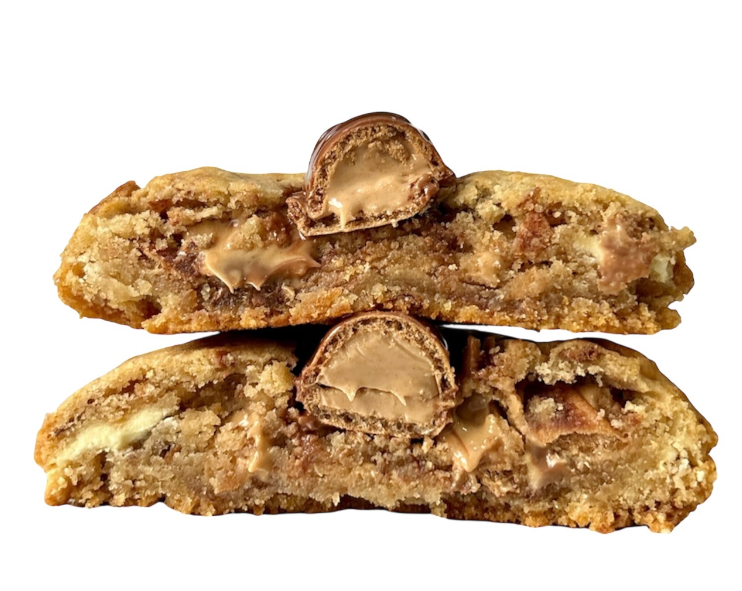 Przekrój przez dwa ciasteczka z kremowym nadzieniem i kawałkami batonika, ułożone jedno na drugim. Widoczne kawałki czekolady i kremu wewnątrz ciasta.