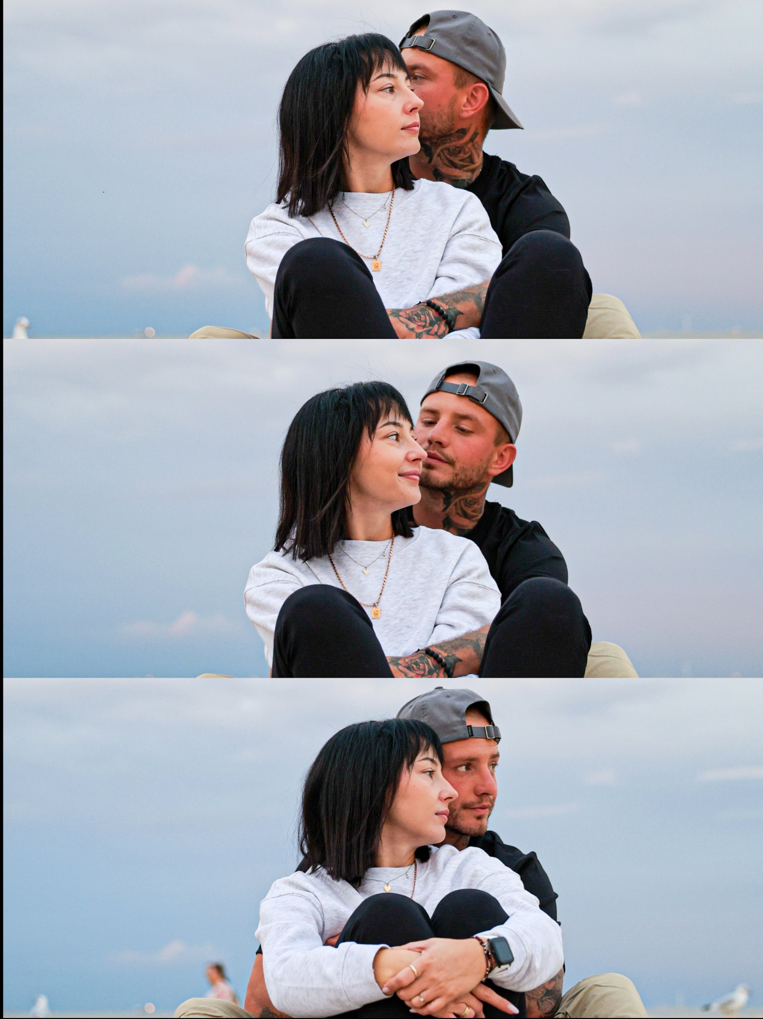Ujęcie zakochanej pary, siedzącej blisko siebie na tle pochmurnego nieba. Mężczyzna w czarnej koszulce i czapce obejmuje kobietę w szarej bluzie. Widoczne tatuaże na ciele.