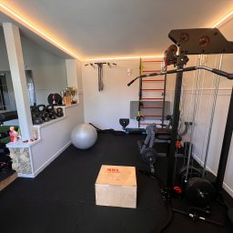 Angelika Noga Power Team - Domowa siłownia z profesjonalnym sprzętem: maszyna do ćwiczeń, drabinki, kettlebells, piłka gimnastyczna i skrzynia do ćwiczeń plyometrycznych. Oświetlenie LED.