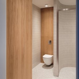 ZPHU Budziński&Motyka s.c. - Nowoczesna łazienka z drewnianą zabudową, podwieszaną toaletą i mozaiką na ścianach. Jasne wnętrze z akcentami drewna i minimalistycznym designem.