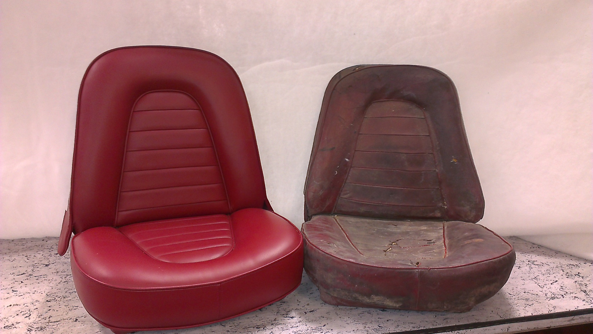 Odnowione czerwone siedzenie samochodowe obok starego, zniszczonego. Widoczny kontrast stanu przed i po renowacji tapicerki.