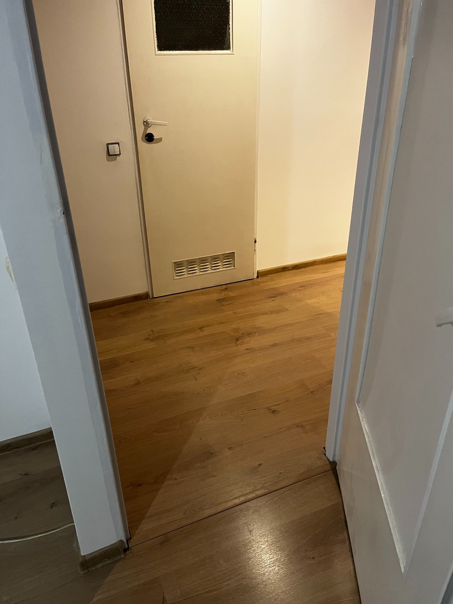 Połączenie salonu z korytarzem – równy i solidny montaż paneli podłogowych w mieszkaniu w Krakowie