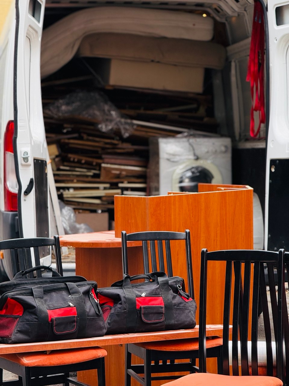 Meble i torby w przestrzeni ładunkowej busa w Elblągu. Widoczne elementy wyposażenia wnętrz, gotowe do transportu. Ujęcie z perspektywy załadunku.