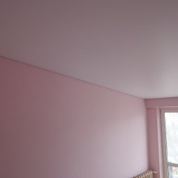 Artlight - Różowa ściana po malowaniu z grzejnikiem i oknem. Widoczny fragment sufitu. Świeżo pomalowane wnętrze w pastelowych barwach.