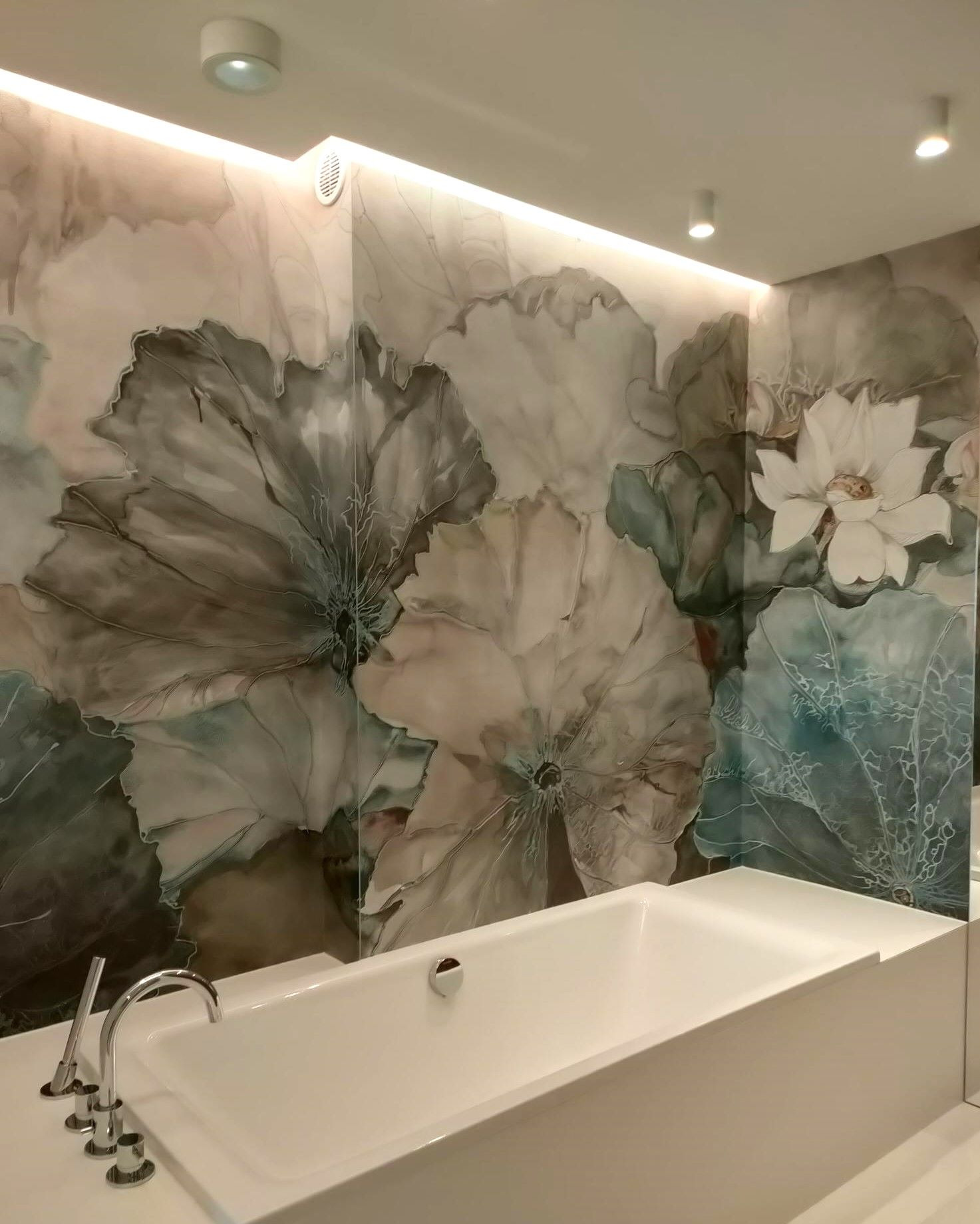 Łazienka z wanną i tapetą w kwiaty lotosu, podświetlona listwą LED. Nowoczesny design z akcentem natury, jasne kolory i minimalistyczne wykończenie.