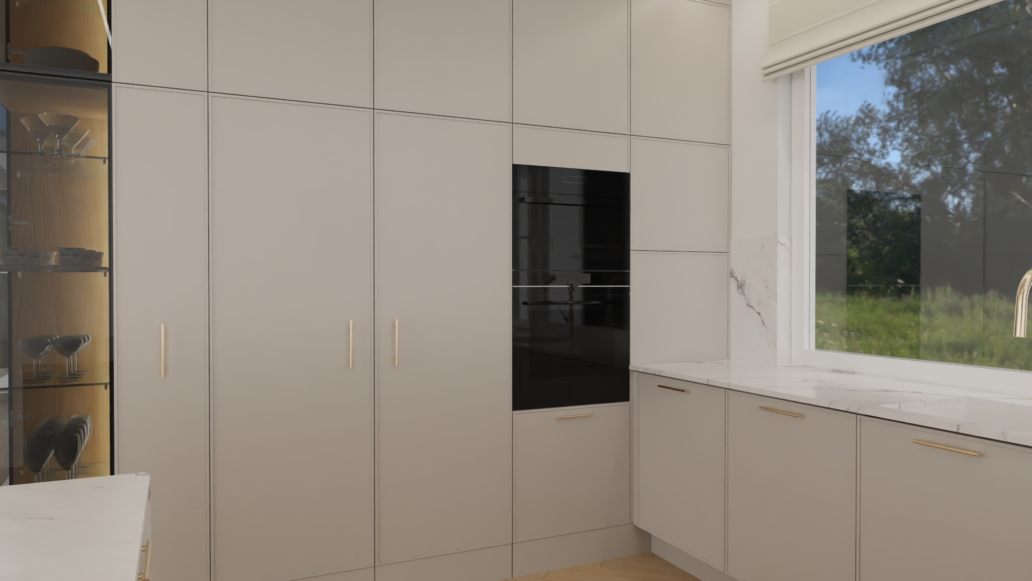 Minimalistyczna kuchnia w beżowych odcieniach z zabudową meblową, szklaną witryną i wbudowanym piekarnikiem. Blat z marmurowym wzorem przy oknie z widokiem na zieleń.