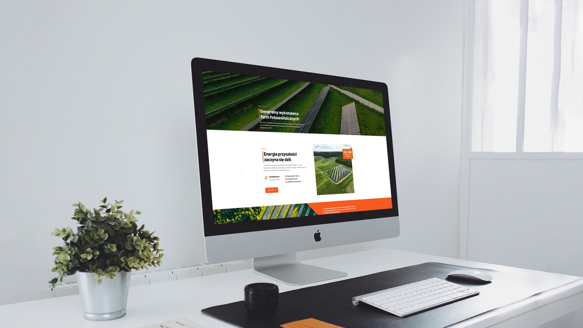 Ekran komputera iMac prezentuje stronę internetową o farmach fotowoltaicznych. Minimalistyczne biurko z rośliną doniczkową i akcesoriami. Jasne, naturalne światło.
