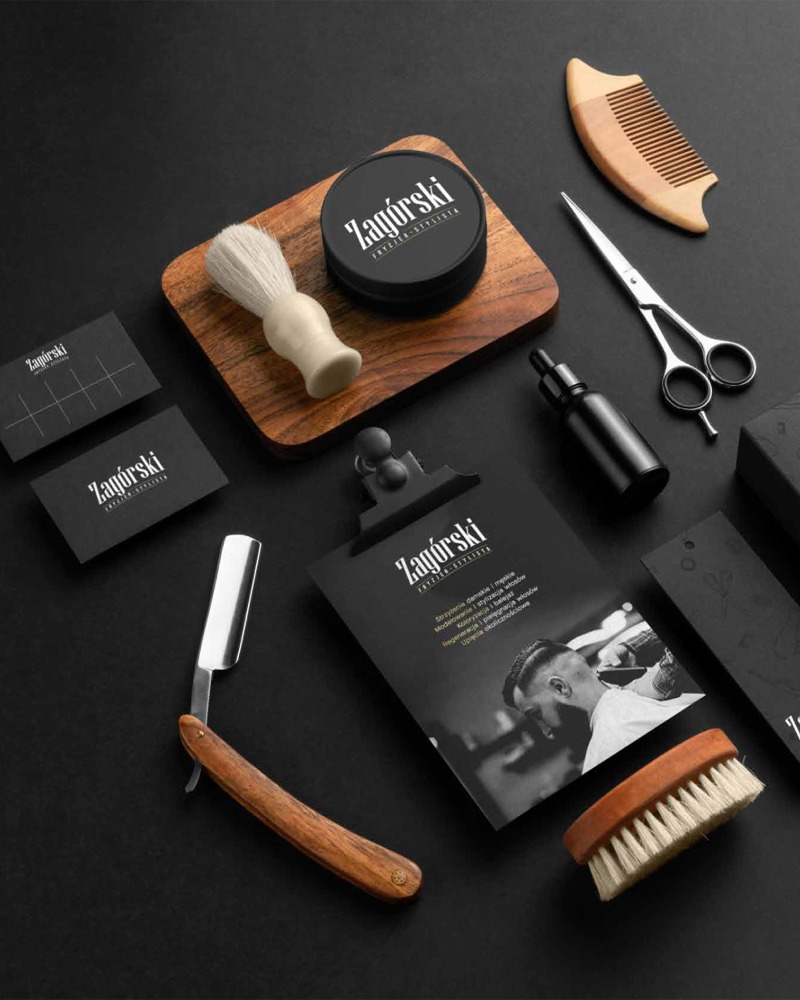 Zestaw barberski na czarnym tle: brzytwa, pędzel do golenia, nożyczki, grzebień, kosmetyki i wizytówki z logo 'Zagórski Fryzjer Stylista'. Elegancki minimalizm.