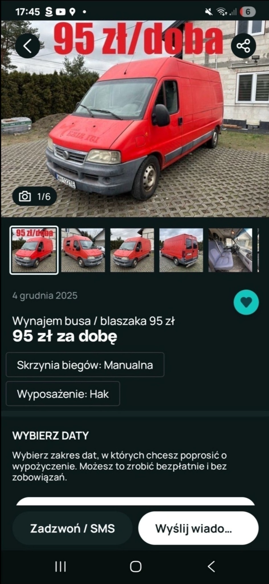 Czerwony bus dostawczy na zewnątrz, widoczny z przodu pod kątem. Na przedniej szybie widnieje napis. Tło stanowią drzewa i budynek. Prezentacja oferty wynajmu.