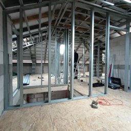 Well Done - Konstrukcja ścian działowych z profili stalowych na poddaszu, widoczne narzędzia i drabina. Etap budowy z płyt karton-gips.