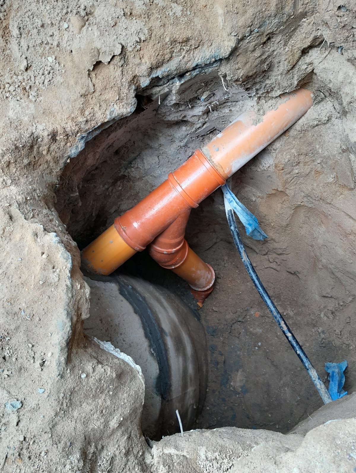 Włączenie kaskadowe przyłącza kanalizacji sanitarnej do studni betonowej na sieci miejskiej