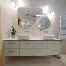 HEXA SC - Nowoczesna łazienka z szafką pod umywalki w odcieniach beżu, asymetryczne lustra i designerskie oświetlenie. Uwagę zwraca minimalistyczny grzejnik drabinkowy.