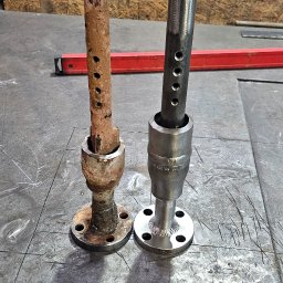 MAR-WELD Marcin Przybyszewski - Porównanie: zardzewiały i odnowiony metalowy element z kołnierzem i otworami, leżące na metalowym stole warsztatowym. Widoczny czerwony poziomica w tle.