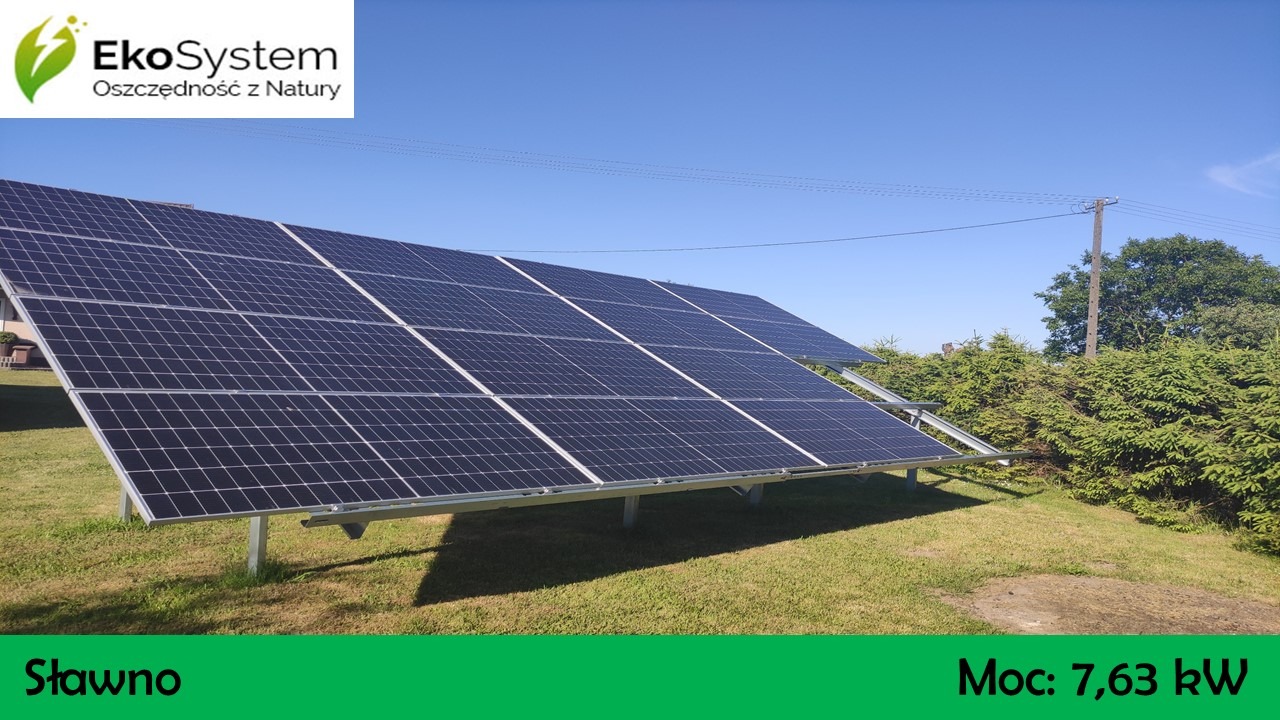 Instalacja paneli słonecznych o mocy 7,63 kW na trawniku, widoczne panele, konstrukcja wsporcza, zieleń i błękitne niebo.