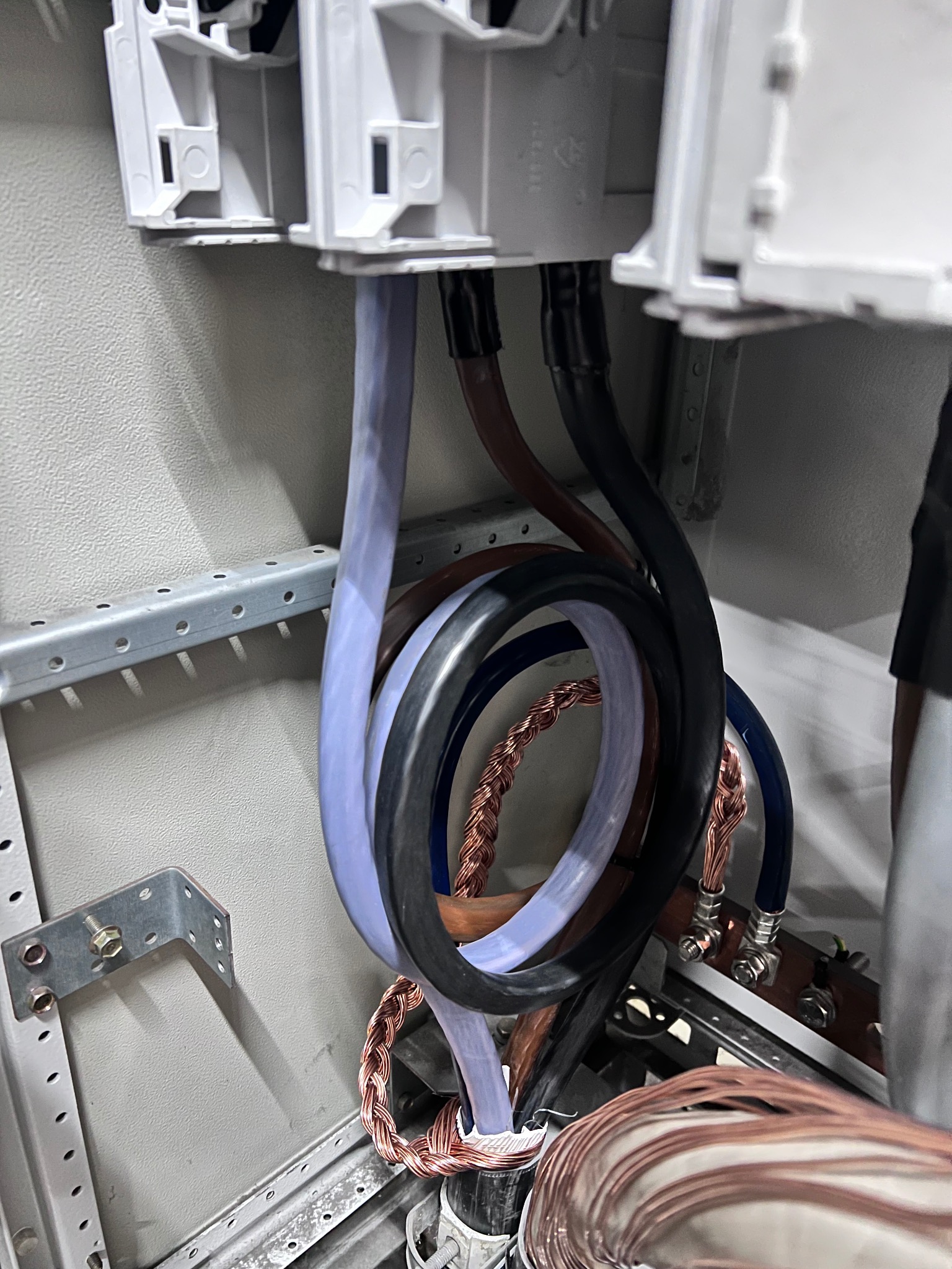 Wnętrze szafy elektrycznej z uporządkowanymi przewodami w różnych kolorach, z widocznymi złączkami i elementami montażowymi. Estetyczne ułożenie kabli.