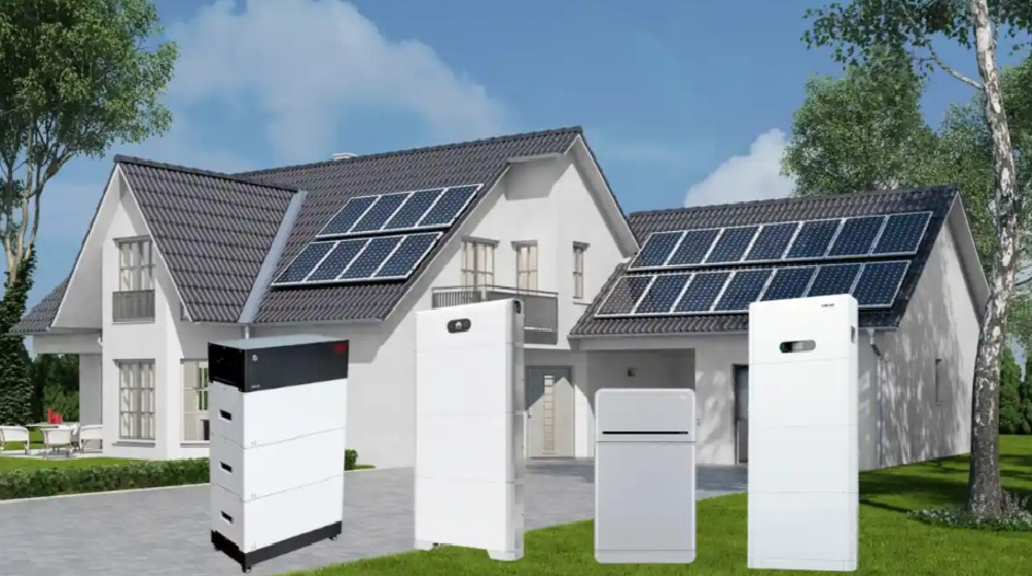 Nowoczesny dom z panelami słonecznymi na dachu i różnymi modelami magazynów energii na trawniku przed budynkiem. Prezentacja systemów fotowoltaicznych i magazynowania energii.