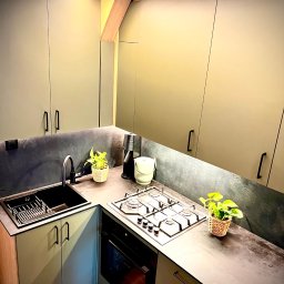 Kuchnia - fronty oliwkowe, blat gr. 12mm HPL, oświetlenie LED, fornir kamienny na ścianie - projekt i wykonanie Dom i Design