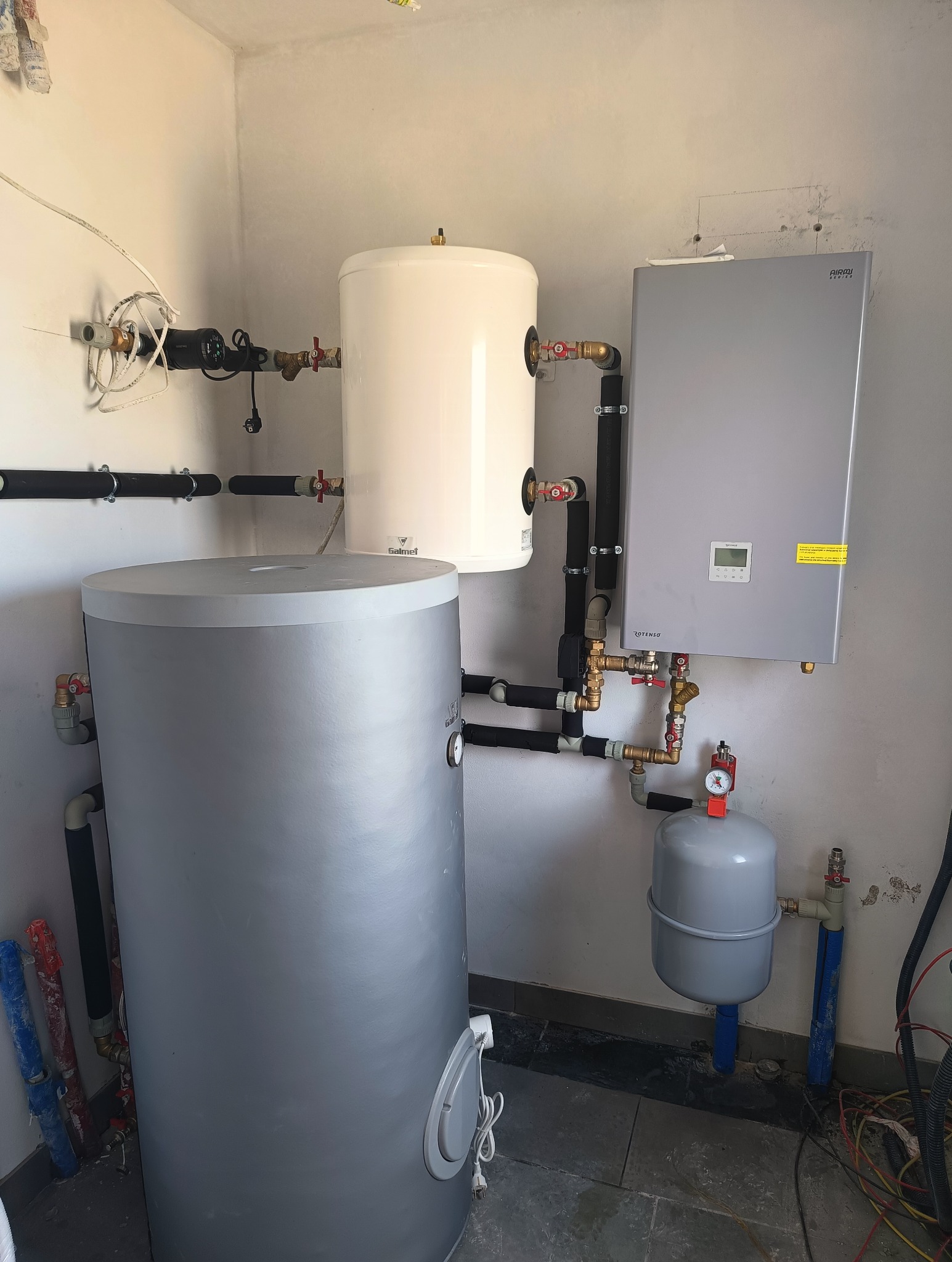 Zmontowana instalacja grzewcza w kotłowni: zbiornik buforowy, zasobnik CWU Galmet, piec gazowy Rotenso, rury z izolacją, zawory. Realizacja instalacji grzewczej.