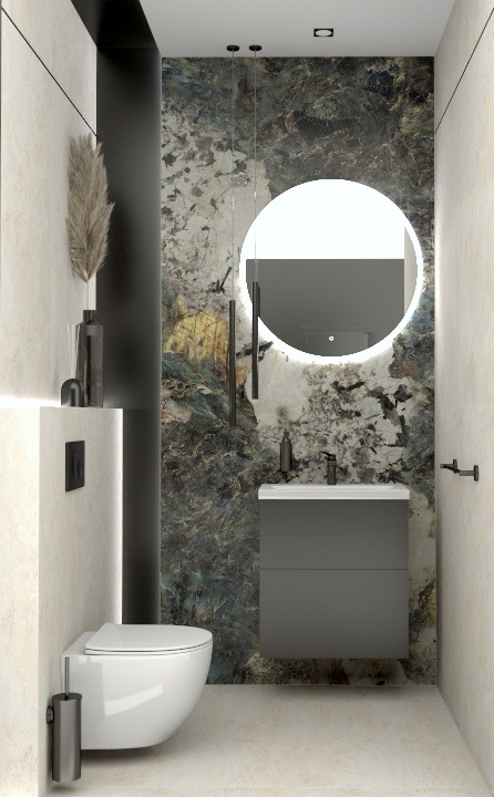 Nowoczesna łazienka z umywalką w szarościach, okrągłym lustrem z podświetleniem LED i toaletą podwieszaną. Na ścianie dekoracyjny panel imitujący kamień.