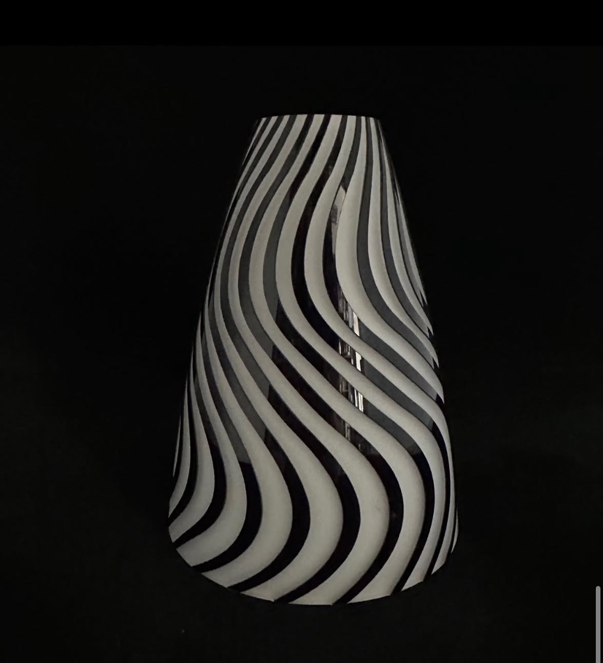 Stożkowa, szklana waza w czarno-białe, faliste pasy na czarnym tle. Unikalny wzór i kształt. Dekoracyjny element wystroju wnętrz.