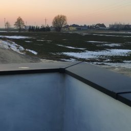 Be-Gro Dachy - Nowoczesne obróbki blacharskie na dachu budynku, widok z góry na tle zimowego krajobrazu o zmierzchu. Detal wykończenia dachu.