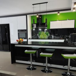 Adrian Hofman - Zabudowa kuchenna 9,5 m. Fronty akryl biały połysk. Blaty czarny granit.