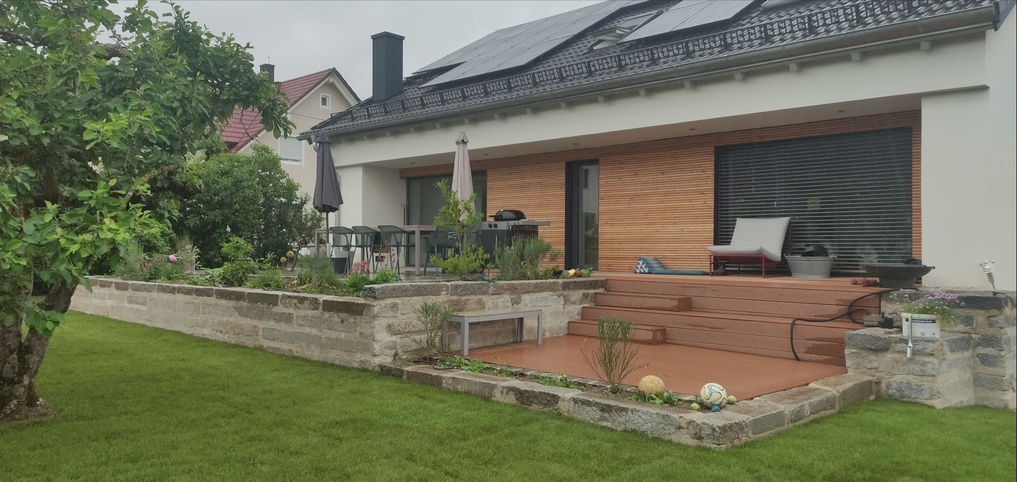 Taras z WPC obłożony blokami granitowymi.