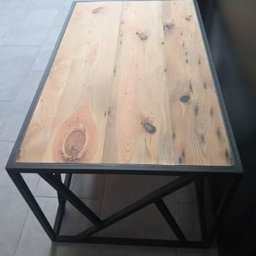 Stolarnia Gwiaździsta Grzegorz Kazanowski - Stolik kawowy z blatem z jasnego drewna i metalową podstawą o geometrycznym wzorze, ustawiony na szarej podłodze.