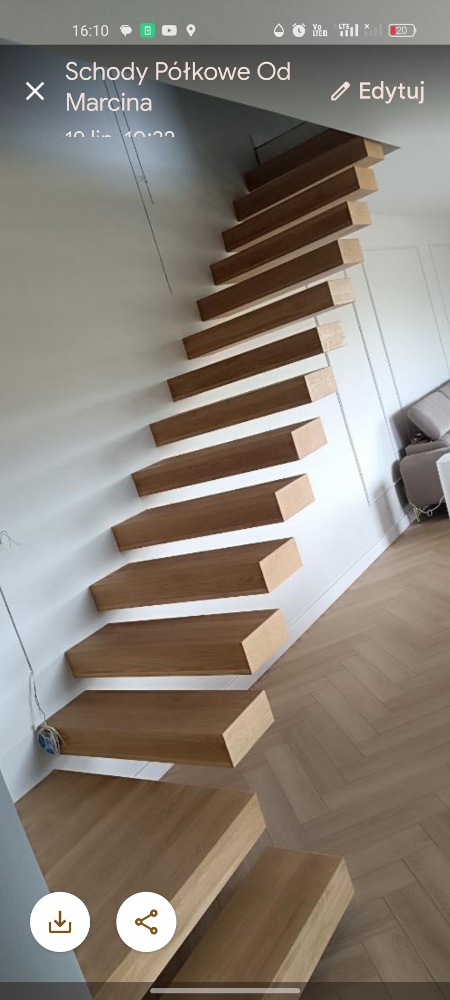 Półkowe schody drewniane, zamocowane do ściany, z widocznym parkietem ułożonym w jodełkę. Minimalistyczny design z elementami dekoracyjnymi na ścianie.