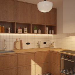 Muka Studio Agnieszka Zielińska-Chmura - Drewniana kuchnia z białymi płytkami i sprzętami: mikser, piekarnik, płyta indukcyjna. Ciepłe oświetlenie podkreśla naturalne materiały i minimalistyczny design.