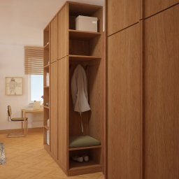 Muka Studio Agnieszka Zielińska-Chmura - Drewniana szafa z otwartymi półkami i miejscem do siedzenia, w tle biurko i regał w jasnym pokoju. Naturalne światło podkreśla ciepły odcień drewna.