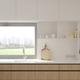 Muka Studio Agnieszka Zielińska-Chmura - Jasna kuchnia z drewnianymi frontami szafek, widokiem na zieleń za oknem i drewnianymi deskami do krojenia na blacie. Minimalistyczny design.