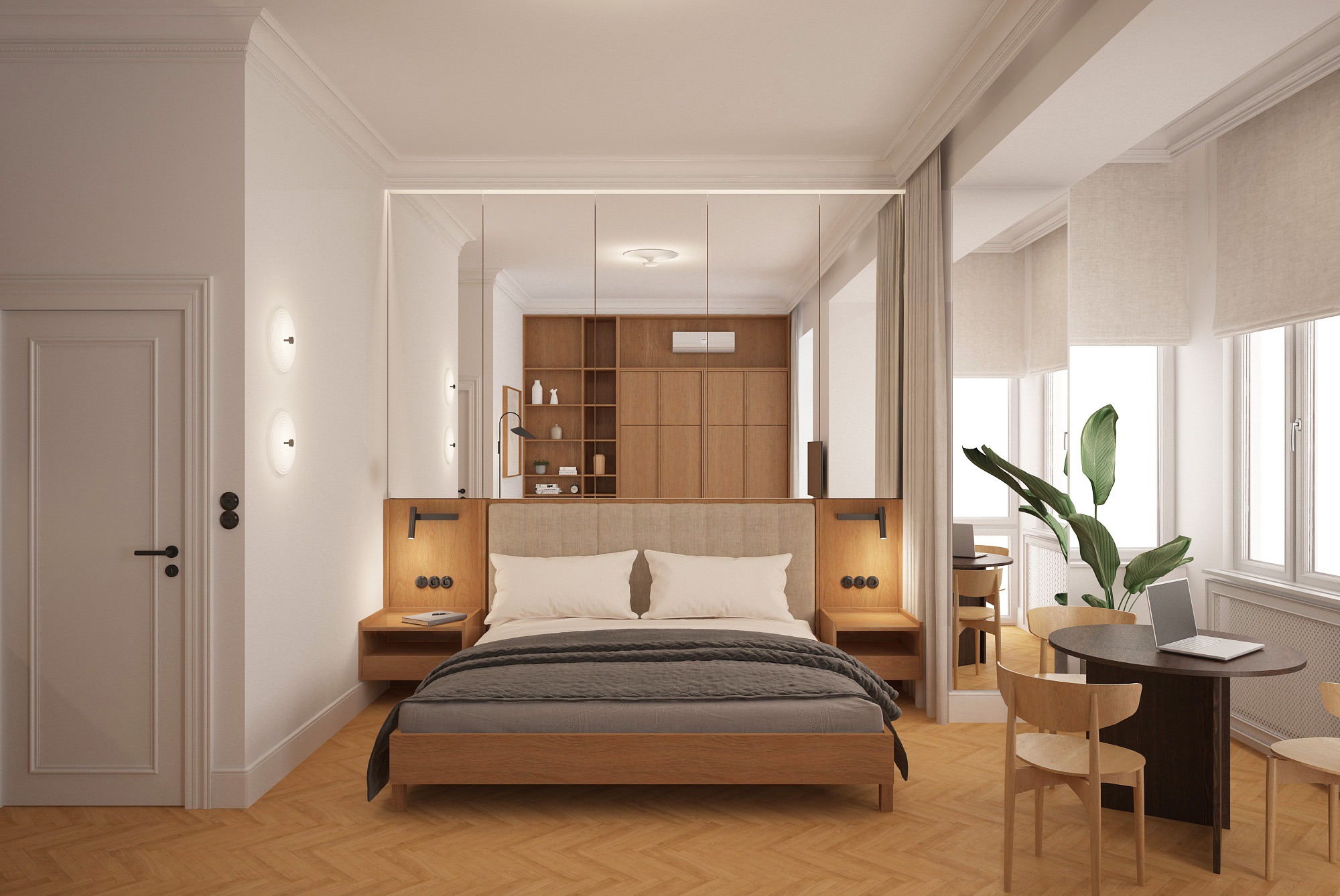 Jasna sypialnia z drewnianą podłogą w jodełkę. Łóżko z zagłówkiem, stoliki nocne z lampkami. W tle stół z laptopem i roślina. Lustrzane panele optycznie powiększają przestrzeń.