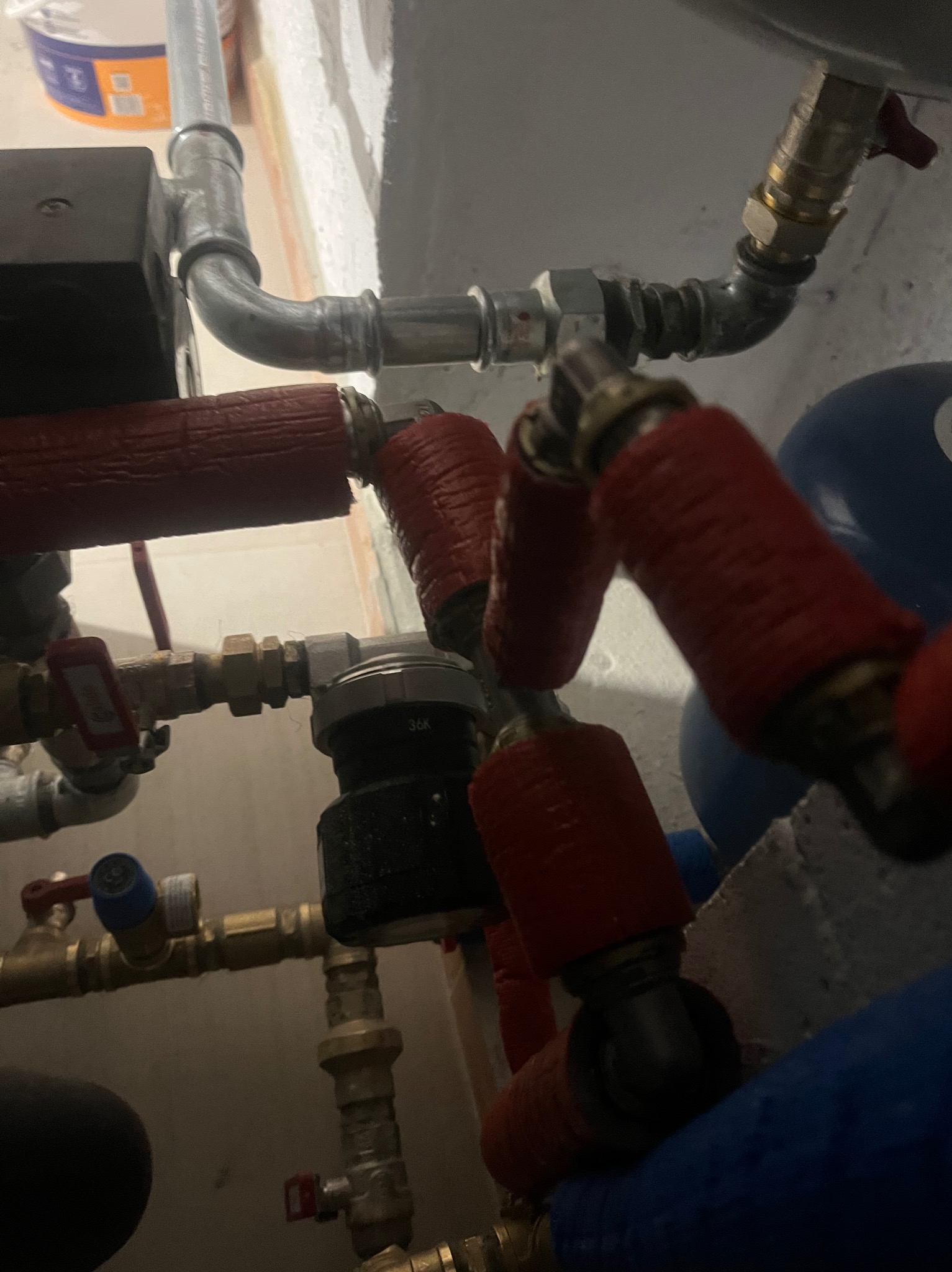 Złożona instalacja rur z izolacją termiczną w Zakopanem. Widoczne zawory, filtry i elementy łączeniowe. Ujęcie z bliska, podkreślające precyzję wykonania.