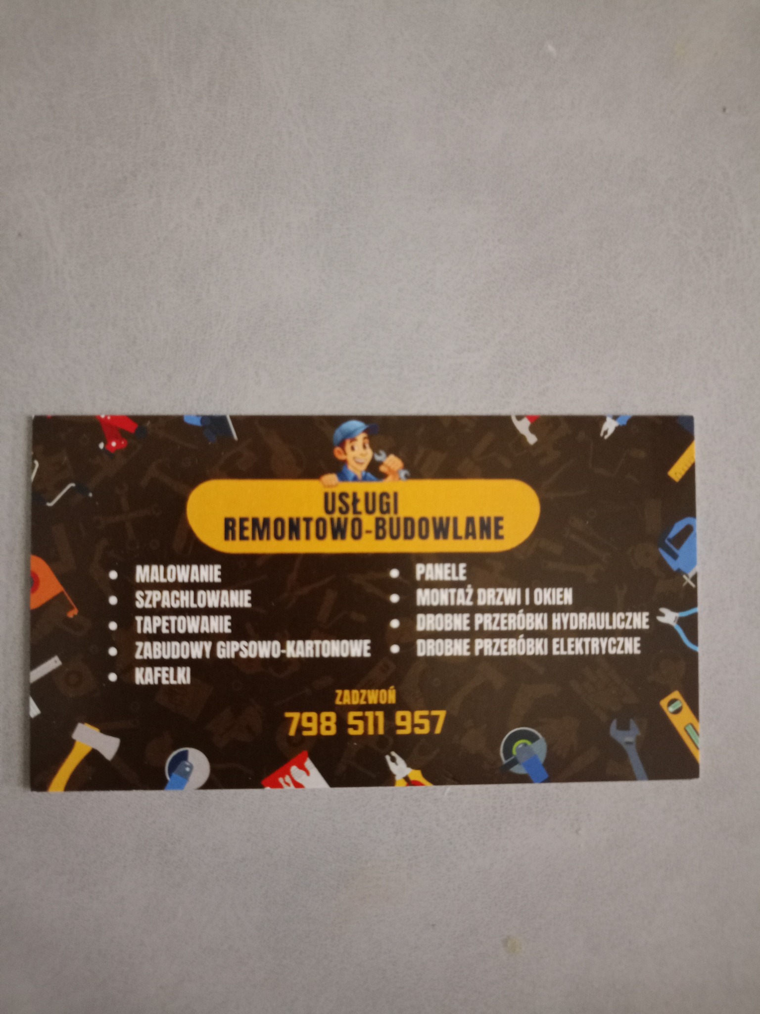 Wizytówka firmy remontowo-budowlanej z listą usług: malowanie, szpachlowanie, tapetowanie, zabudowy gips-karton, kafelki, panele, montaż drzwi i okien, drobne przeróbki.