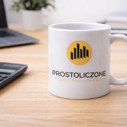 Biuro Rachunkowe Prostoliczone Małgorzata Trefler - Kubek z logo 'Prostoliczone Biuro Rachunkowe' na biurku z kalkulatorem i laptopem. Minimalistyczny design, ciepłe oświetlenie, buduje profesjonalny wizerunek.