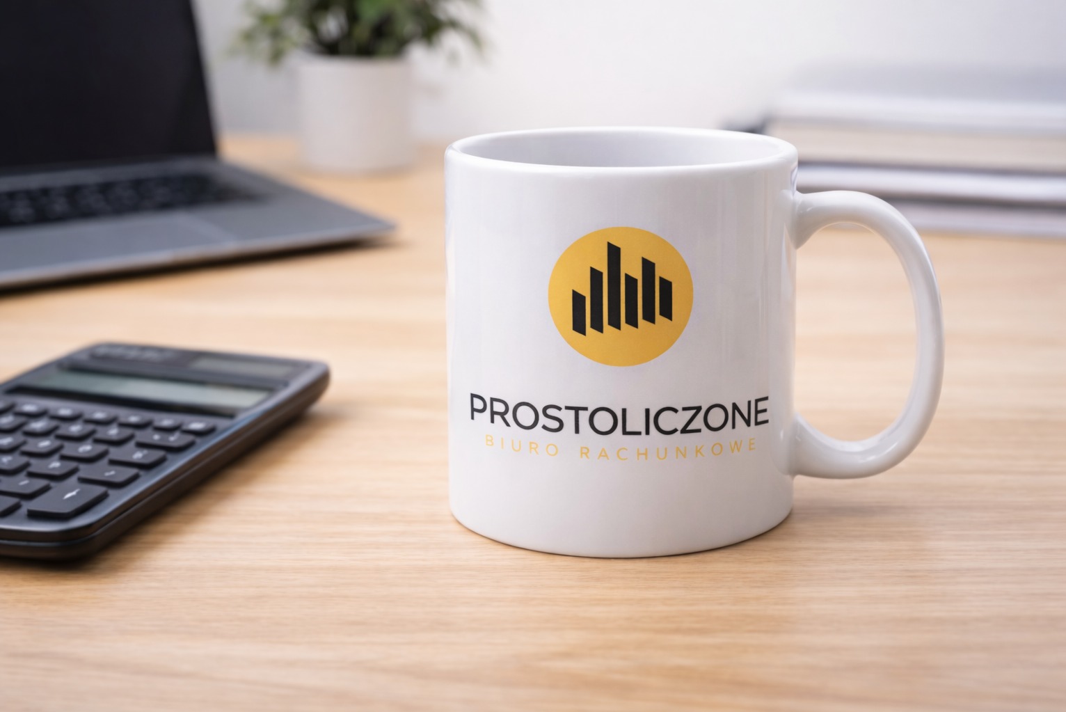Kubek z logo 'Prostoliczone Biuro Rachunkowe' na biurku z kalkulatorem i laptopem. Minimalistyczny design, ciepłe oświetlenie, buduje profesjonalny wizerunek.