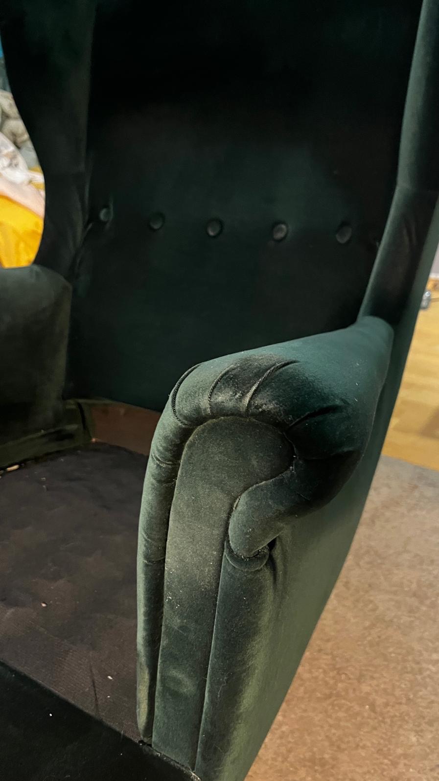 Szczegółowe ujęcie brudnego, zielonego fotela tapicerowanego z widocznymi plamami i kurzem na podłokietniku, wymagającego czyszczenia.