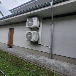 COLD-RES Dominik Markowski - Dwa białe klimatyzatory Sinclair zamontowane na elewacji domu, z widocznymi rurami odprowadzającymi skropliny i elementami instalacji zewnętrznej.