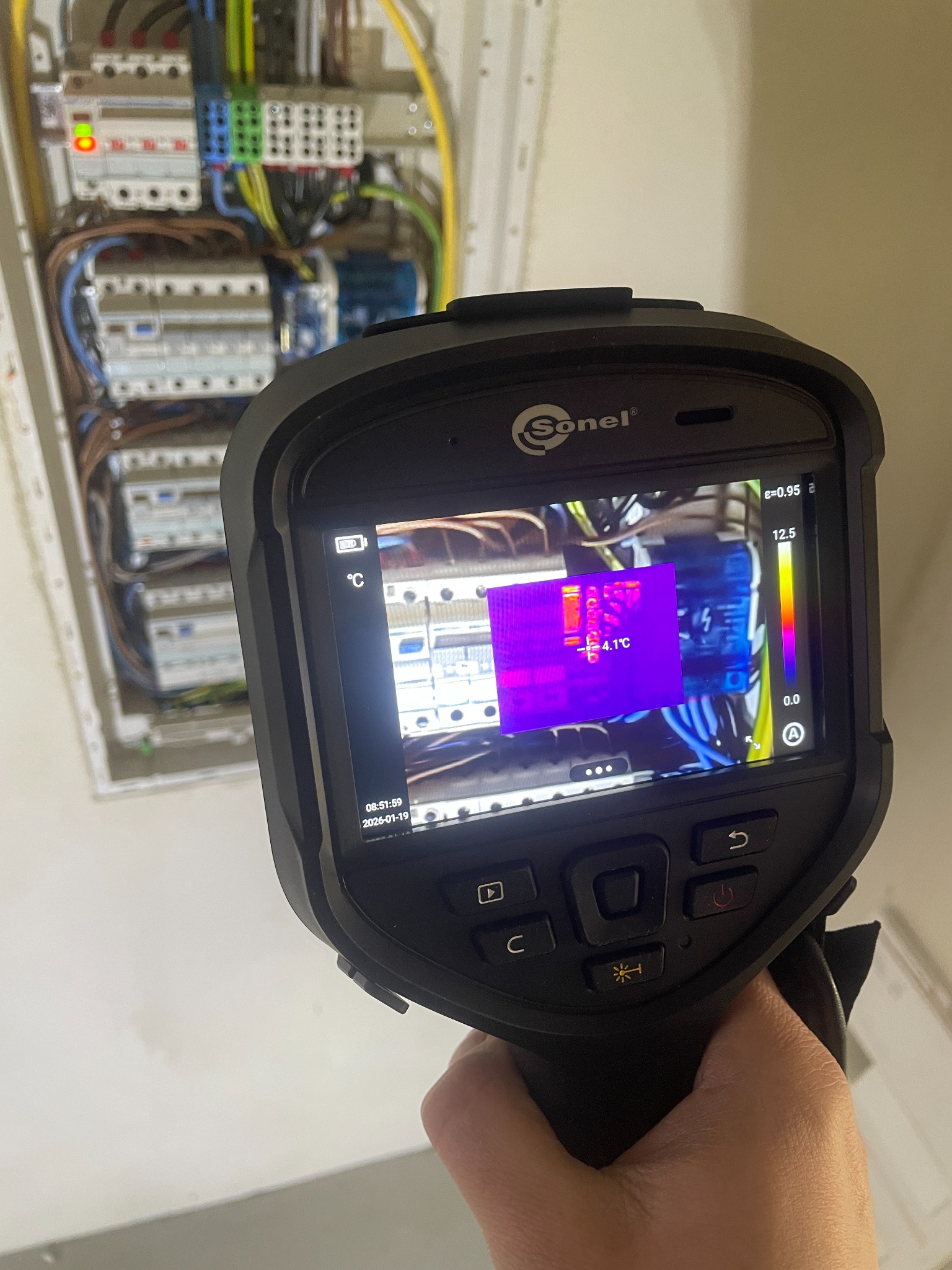 Termowizja rozdzielnicy elektrycznej z użyciem kamery Sonel, ukazująca rozkład temperatur na elementach. Diagnostyka instalacji elektrycznej w trakcie pracy.