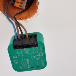 DB ElektroSystem - Montaż inteligentnego włącznika światła ZaMel SRW-01 w puszce elektrycznej, widoczne złącza WAGO. Instalacja elektryczna w trakcie podłączania.