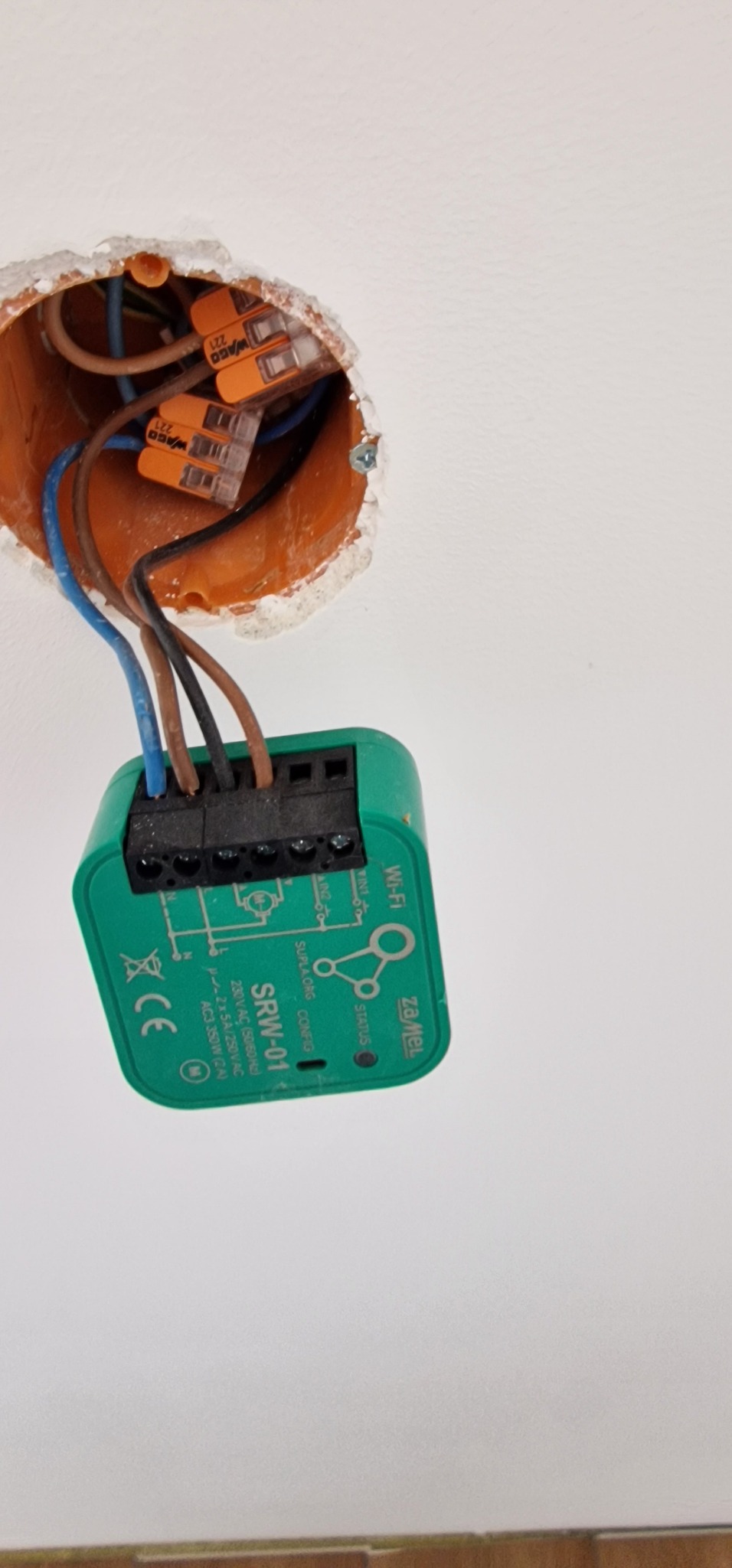 Montaż inteligentnego włącznika światła ZaMel SRW-01 w puszce elektrycznej, widoczne złącza WAGO. Instalacja elektryczna w trakcie podłączania.