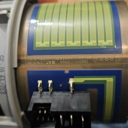 Piotr Meller Energia w Dobrym Klimacie - Grzałka indukcyjna EGO z widocznymi elementami elektrycznymi i oznaczeniami technicznymi, trzymana w dłoni, z bliska. Widoczne złącza i płytka z obwodem.