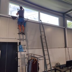 Mycie okien ręcznie przy pomocy drabin