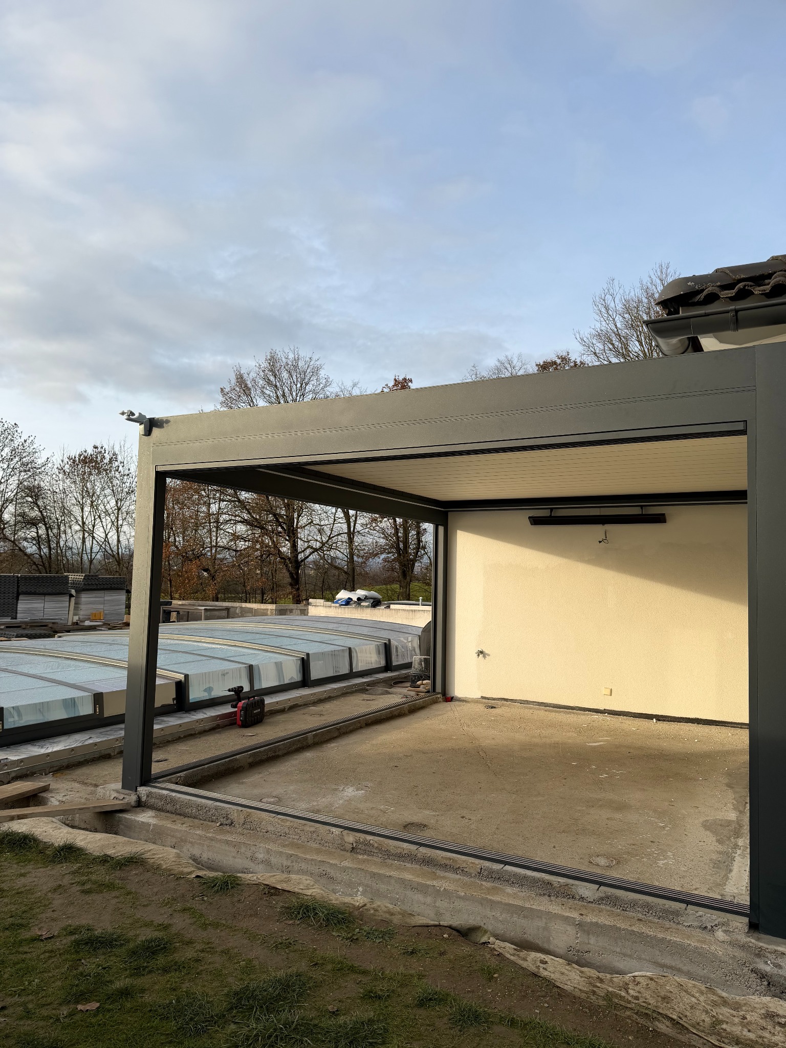 Nowoczesna pergola metalowa w Czańcu, z widocznym systemem przesuwnych paneli dachowych i przygotowanym podłożem. Minimalistyczny design i solidna konstrukcja.