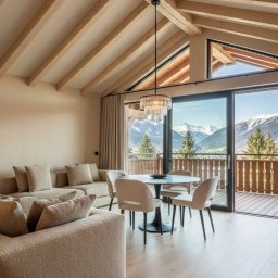 Safeapartments - zarządzanie wynajmem krótkoterminowym - Jasne wnętrze apartamentu z drewnianą konstrukcją stropu, sofą, stołem i widokiem na góry z balkonu. Nowoczesny design z elementami rustykalnymi.