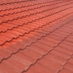 SEDONA AUTO MARCIN POKORSKI - Czerwona dachówka ceramiczna, częściowo umyta, ukazująca różnicę w kolorze i czystości. Widoczny kontrast między czystą a zabrudzoną powierzchnią dachu.