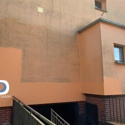 Częściowo umyta elewacja budynku w kolorze brzoskwiniowym, widoczne różnice w czystości. W lewym dolnym rogu logo firmy PROWASH.