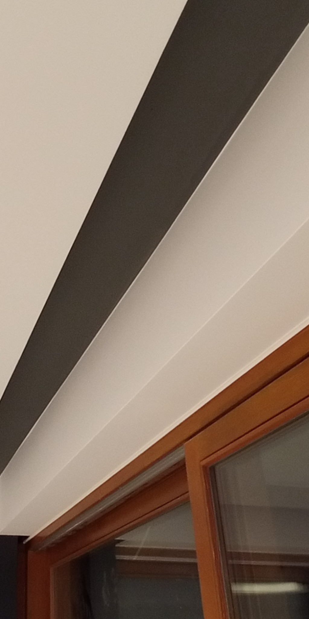 Pomysłowe malowanie sufitu w paski, z widocznym fragmentem okna. Kontrastowe kolory i precyzyjne wykonanie. Nowoczesny design wnętrza.